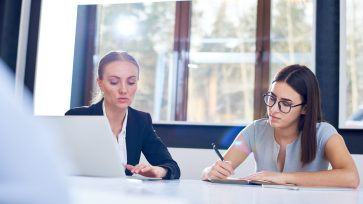 Woman coaching her employee to improve her business writing skills with Learn2